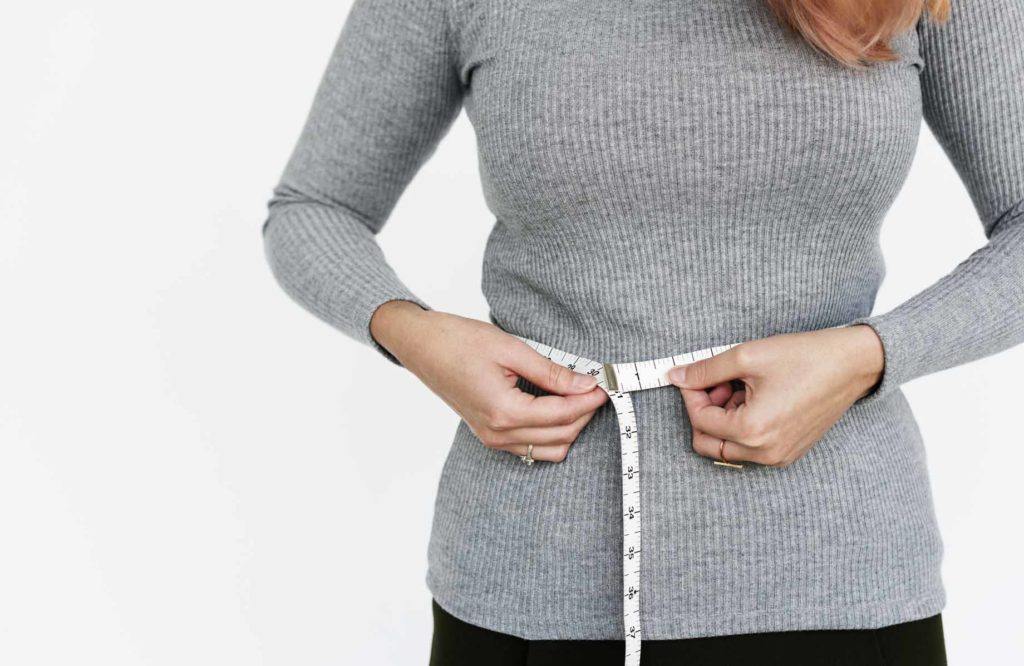 Woman measuring her waist